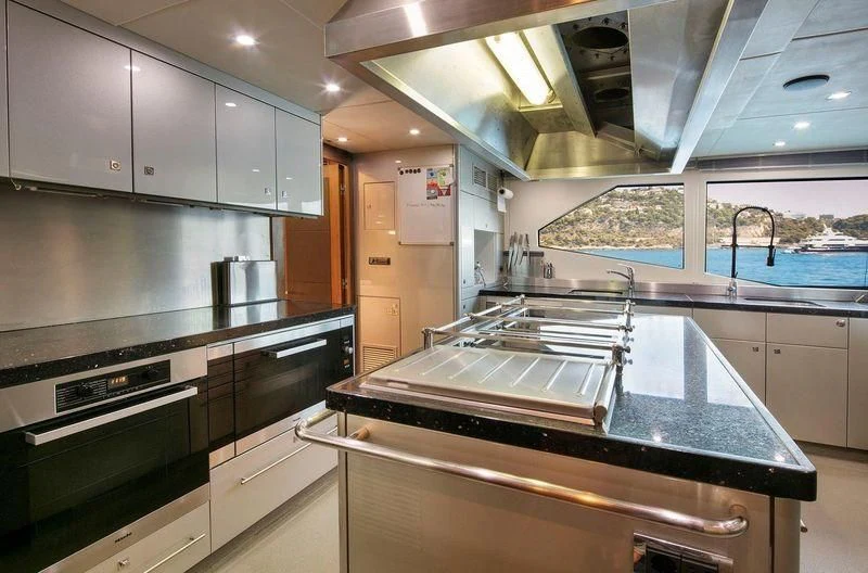 a kitchen with stainless steel appliances aboard THE DEVOCEAN Yacht for Sale