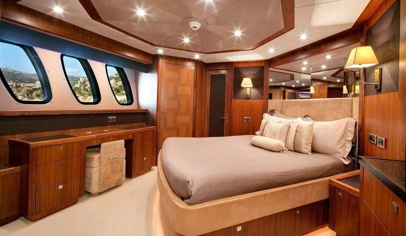 a room with a bed and a desk aboard THE DEVOCEAN Yacht for Sale