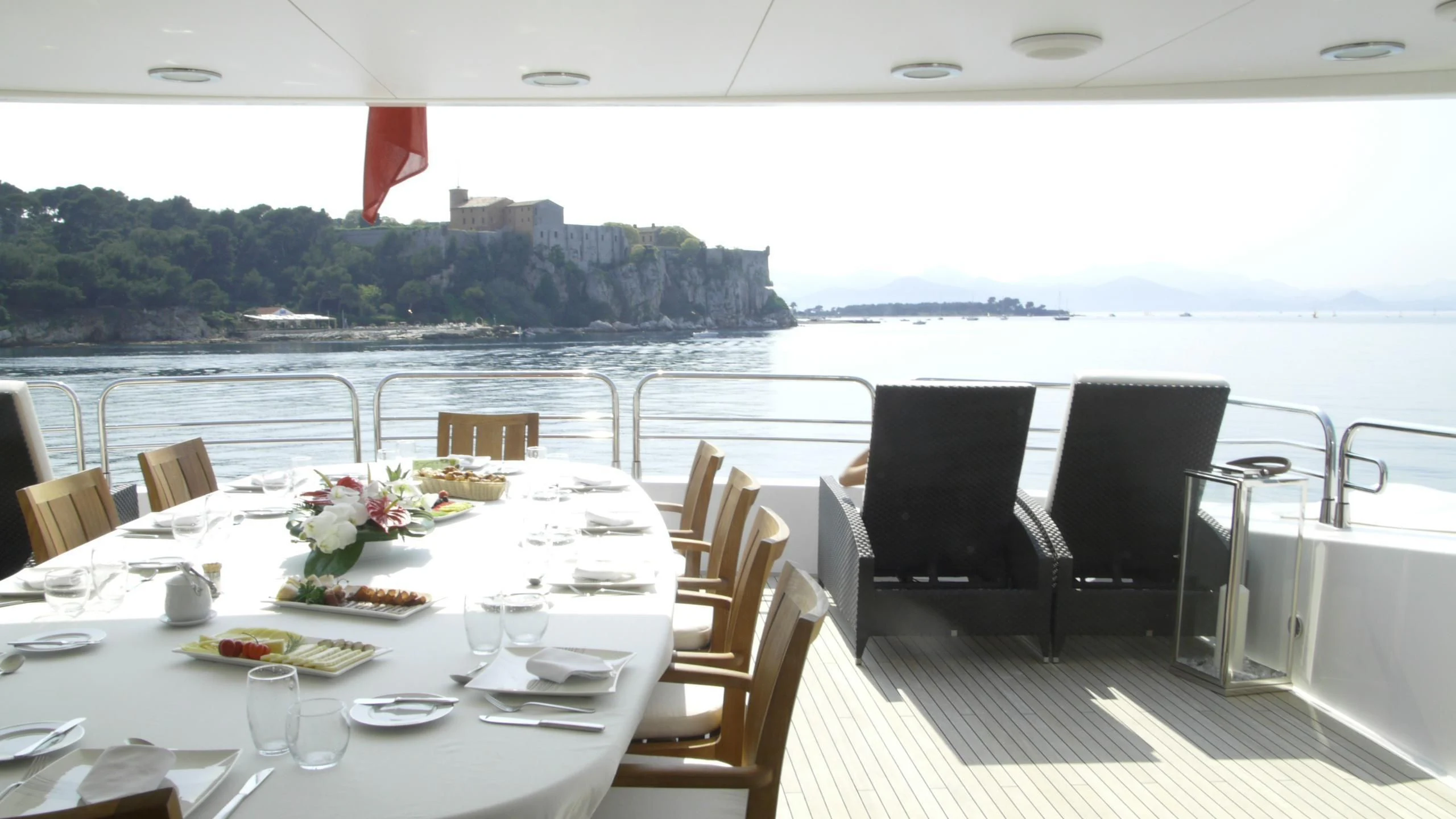 a table set for a meal on a deck overlooking a large body of water aboard THE DEVOCEAN Yacht for Sale
