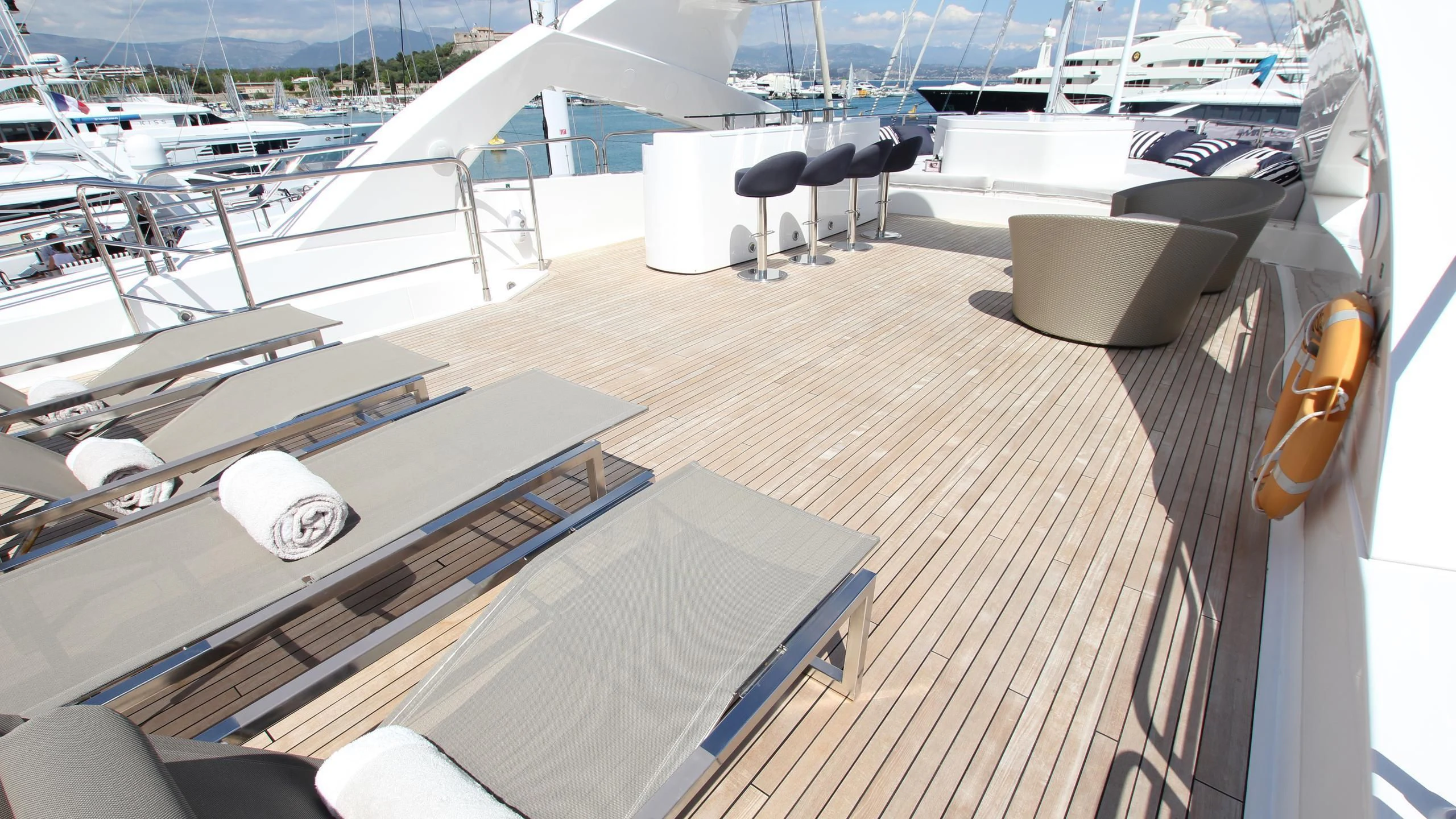 a deck with a deck and a boat in the water aboard THE DEVOCEAN Yacht for Sale