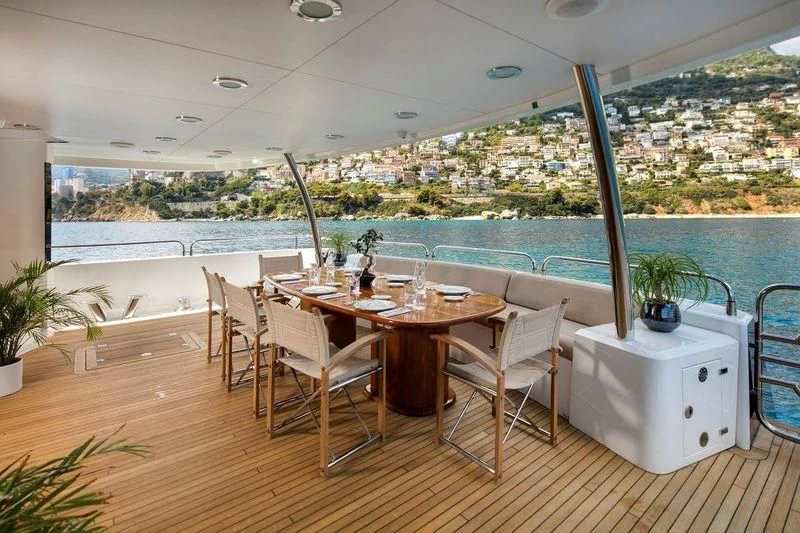 a table and chairs on a balcony aboard THE DEVOCEAN Yacht for Sale