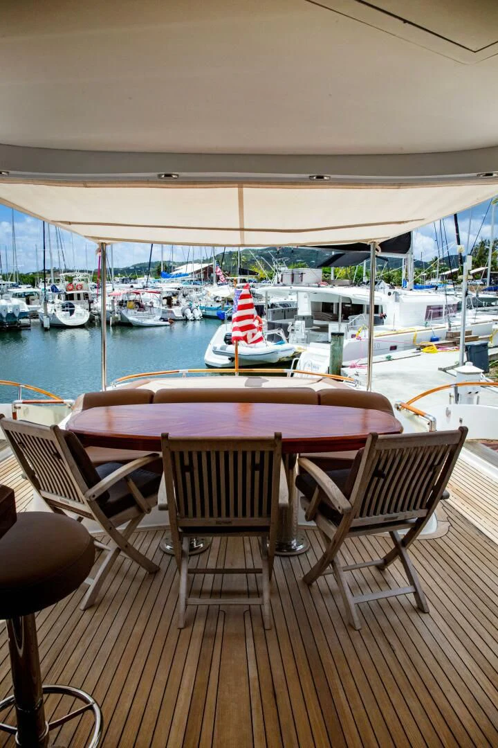 a table and chairs on a deck overlooking a marina with boats aboard LOVIN LIFE Yacht for Sale