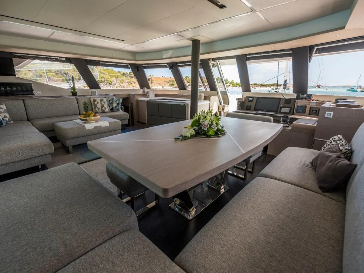a room with a table and couches aboard LISA OF THE SEAS Yacht for Sale