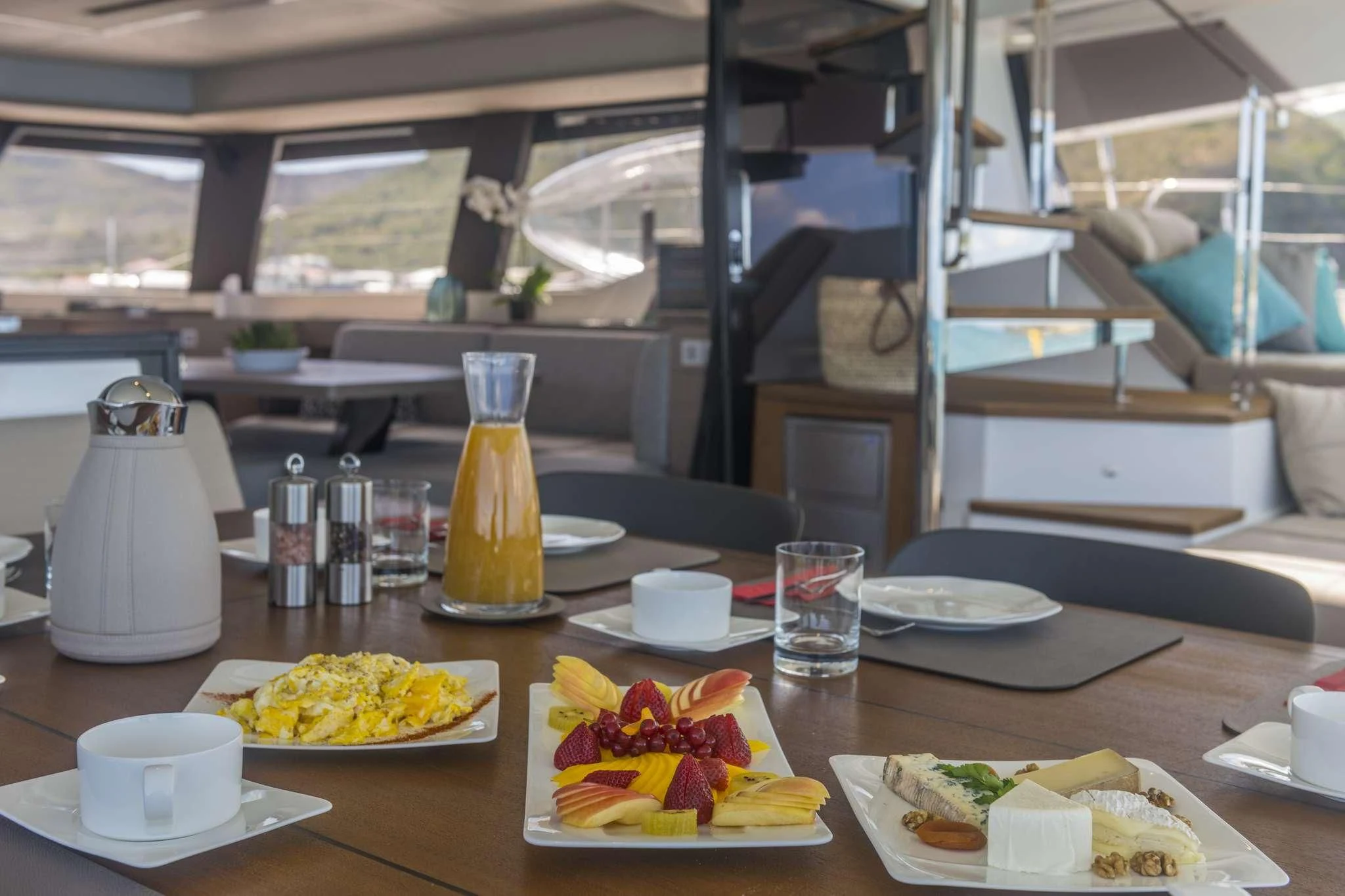 a table with plates of food and cups on it aboard LISA OF THE SEAS Yacht for Sale
