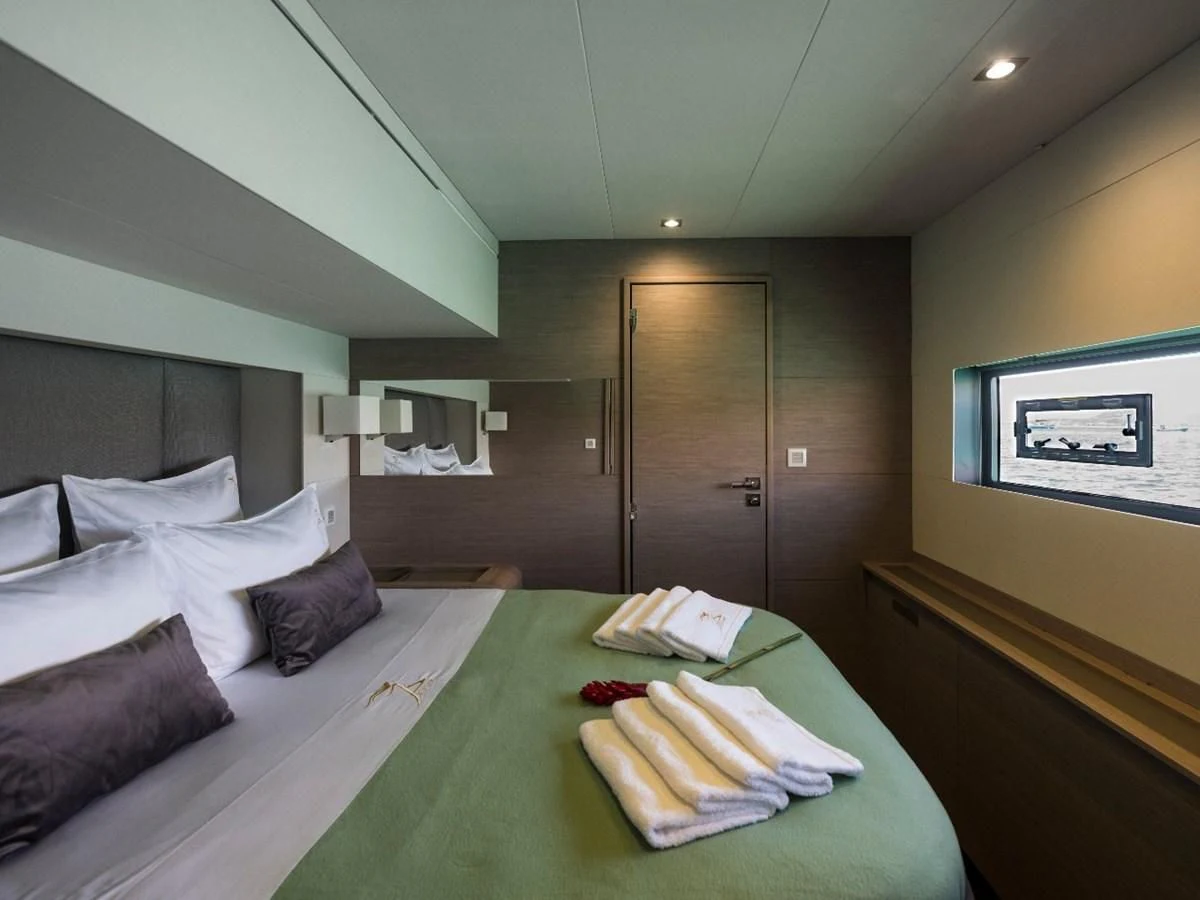 a bed with a green tablecloth aboard LISA OF THE SEAS Yacht for Sale