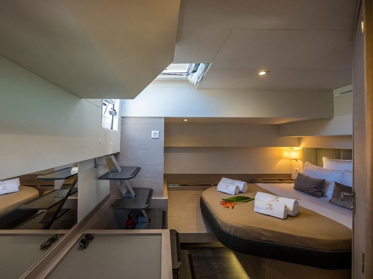 a room with a bed and desk aboard LISA OF THE SEAS Yacht for Sale