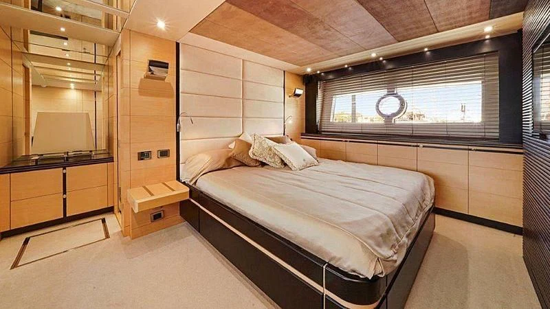 a room with a bed and a desk aboard LIMITLESS Yacht for Sale