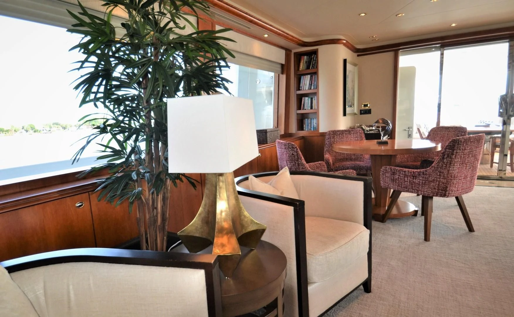 a living room with a lamp and a table with chairs aboard INTUITION Yacht for Sale