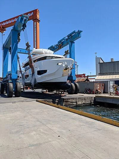 a large white boat on a crane aboard KAI Yacht for Sale