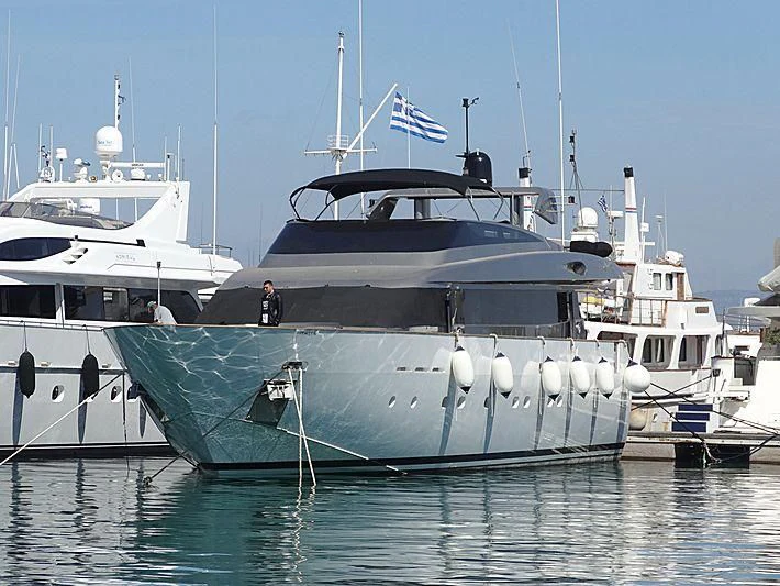 a large white boat with a flag on it with USS Potomac (AG-25) in the background aboard CORAL Yacht for Sale