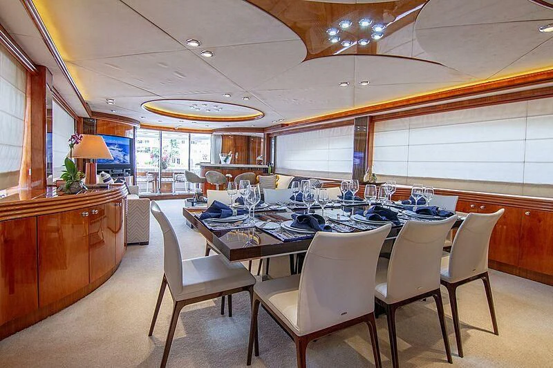 a large dining room with a large table and chairs aboard #OMG Yacht for Sale