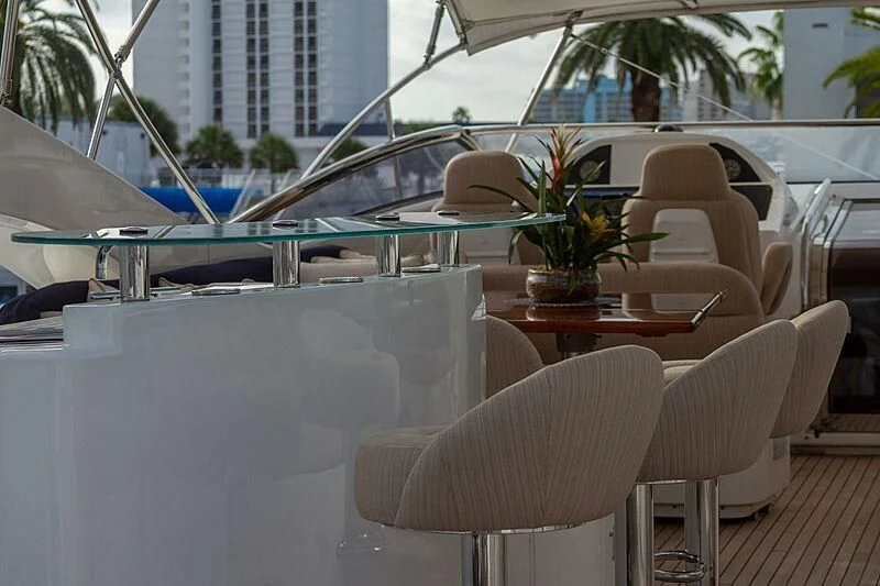 a table with chairs and a pool aboard #OMG Yacht for Sale