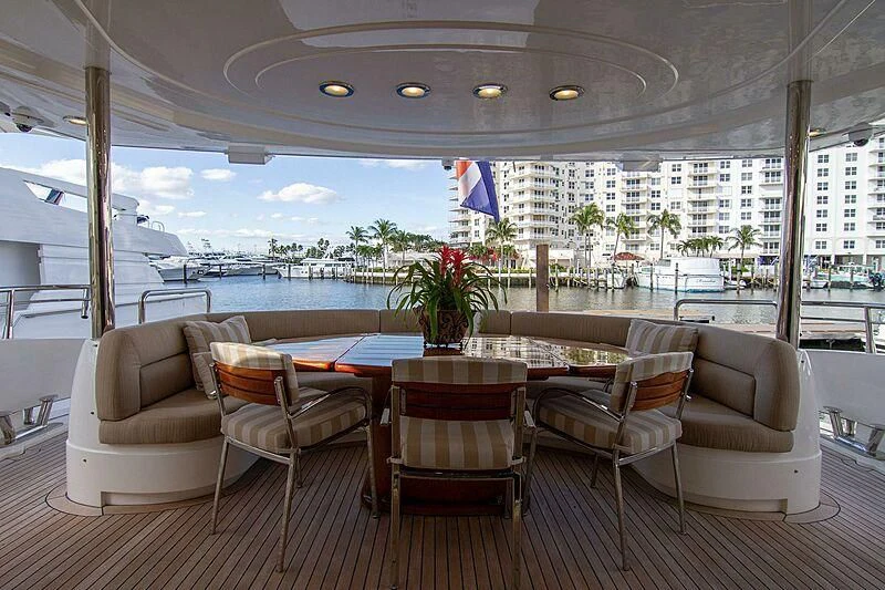 a room with a table chairs and a view of the water aboard #OMG Yacht for Sale