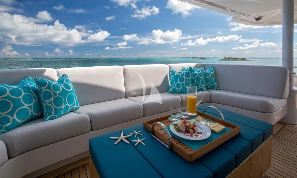 a couch with a table and a glass of juice on it aboard DREAM Yacht for Sale