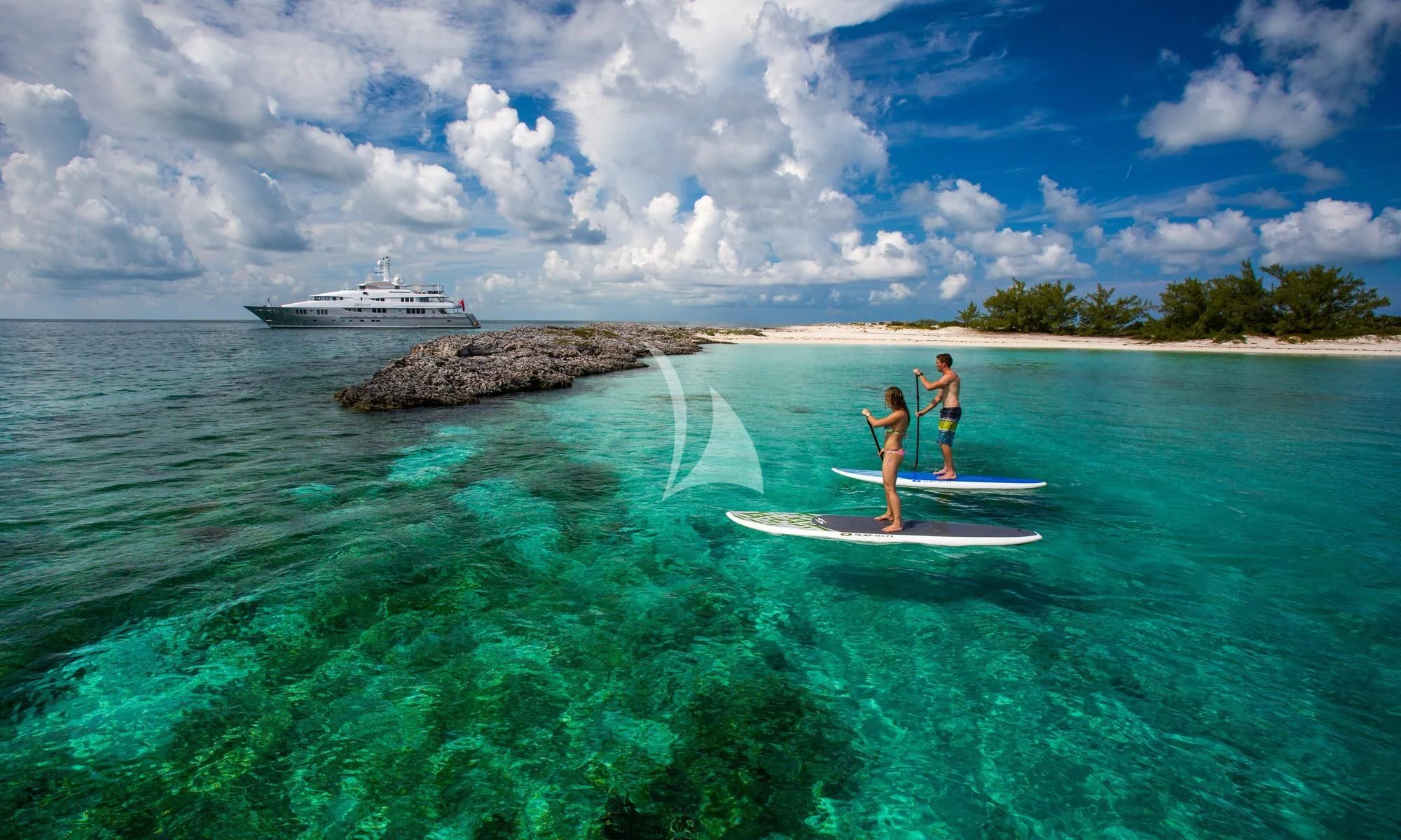 a couple of people on surfboards in the ocean aboard DREAM Yacht for Sale