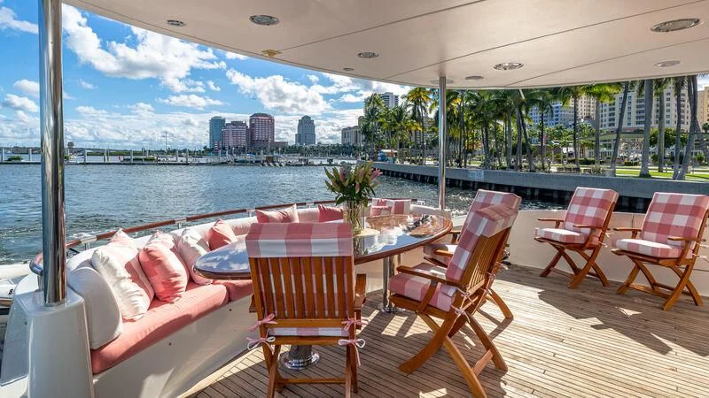 a table and chairs on a deck overlooking a city aboard HOPE FLOATS Yacht for Sale