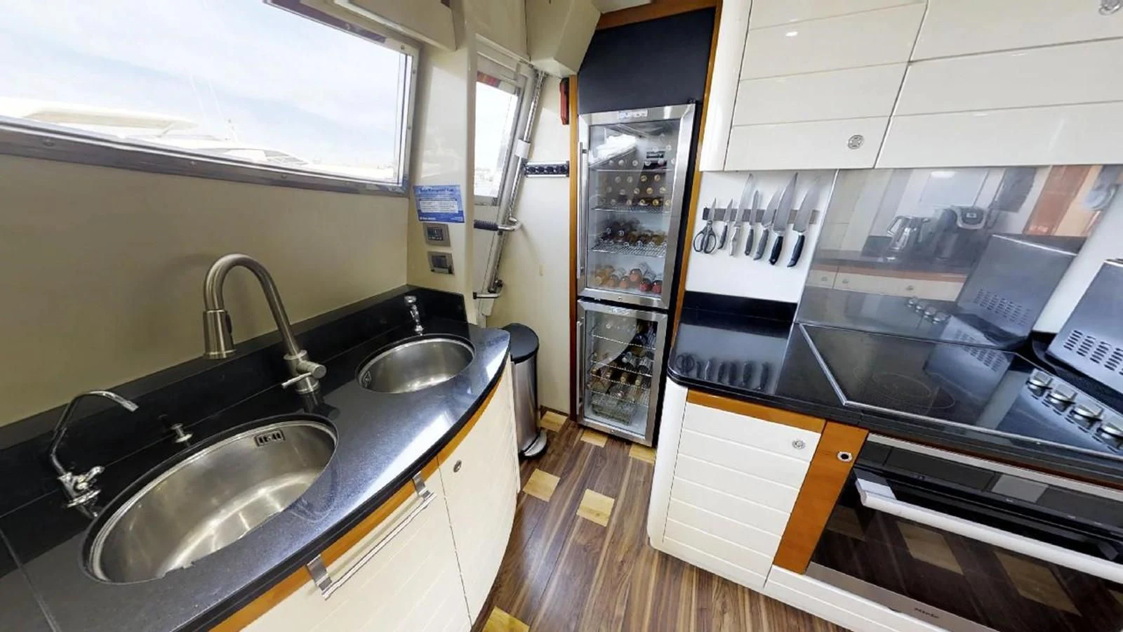 a kitchen with a sink and a refrigerator aboard INDULGE II Yacht for Sale