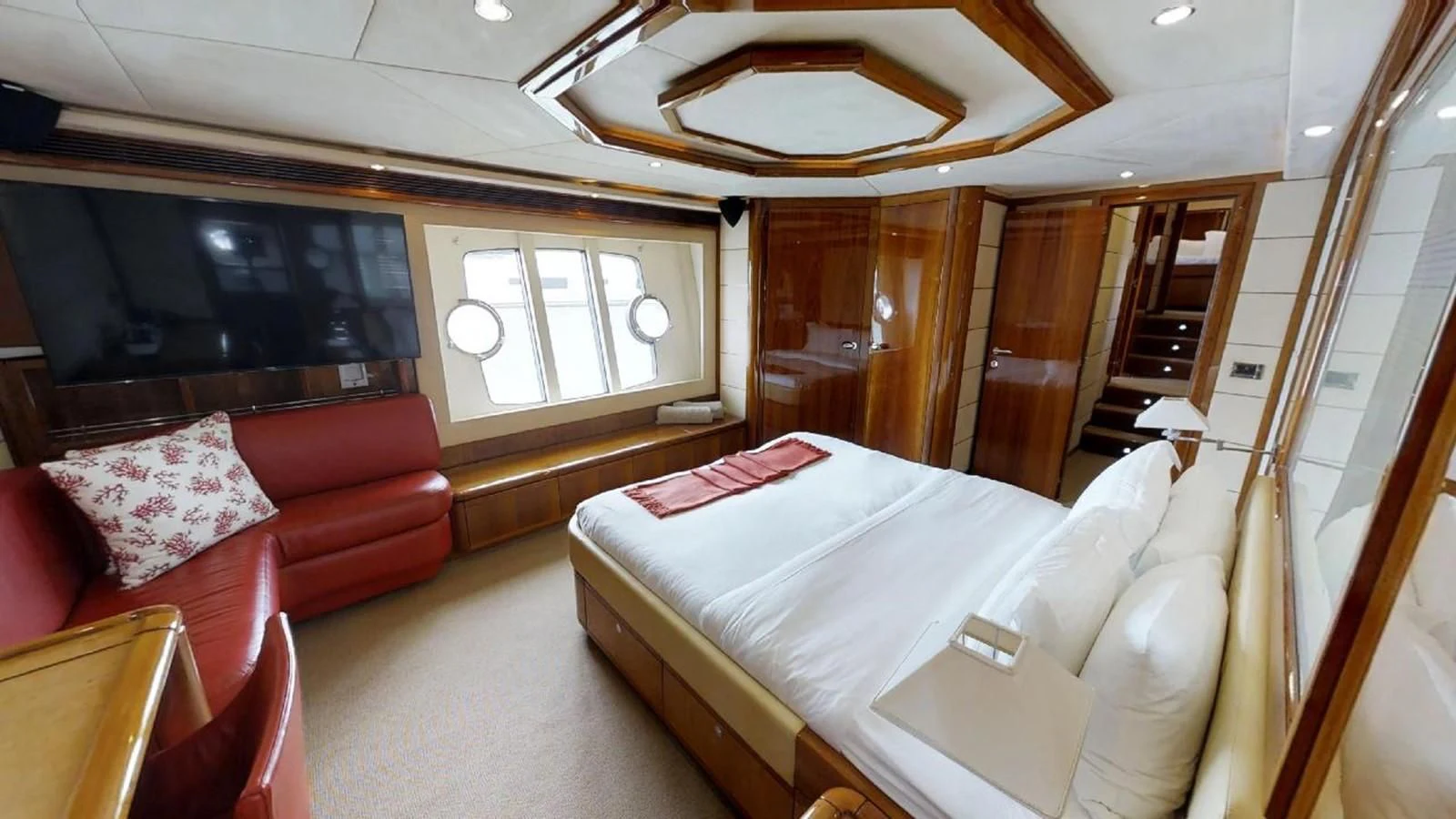 a bedroom with a bed and a couch aboard INDULGE II Yacht for Sale