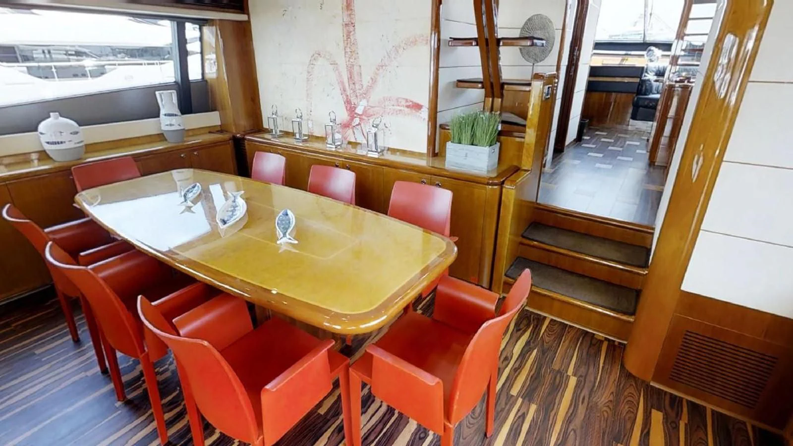 a dining room with red chairs aboard INDULGE II Yacht for Sale