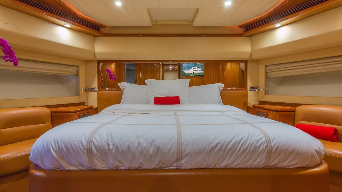 a bed with white sheets and pillows aboard INDULGE II Yacht for Sale