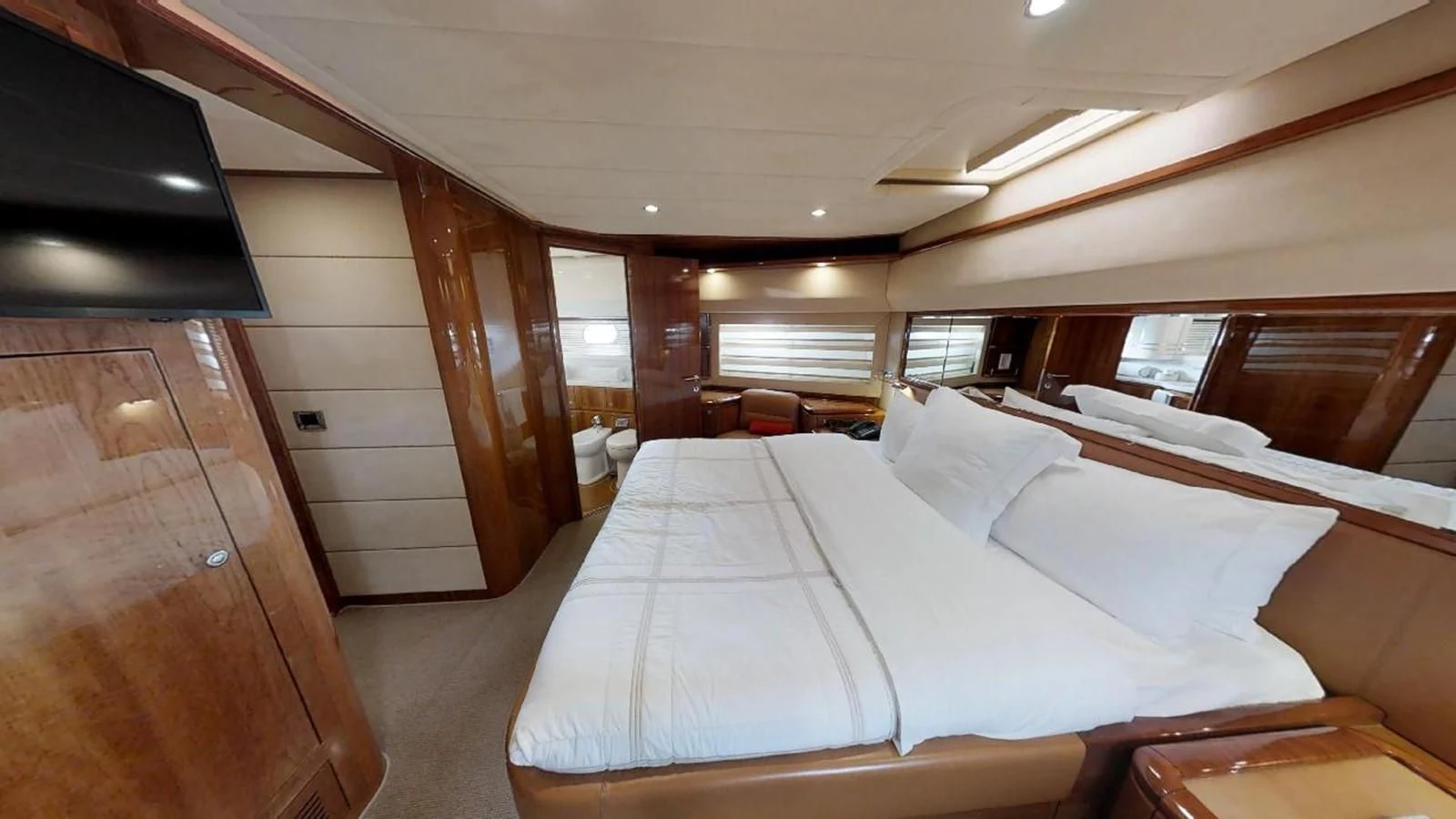a room with a bed and a wood door aboard INDULGE II Yacht for Sale
