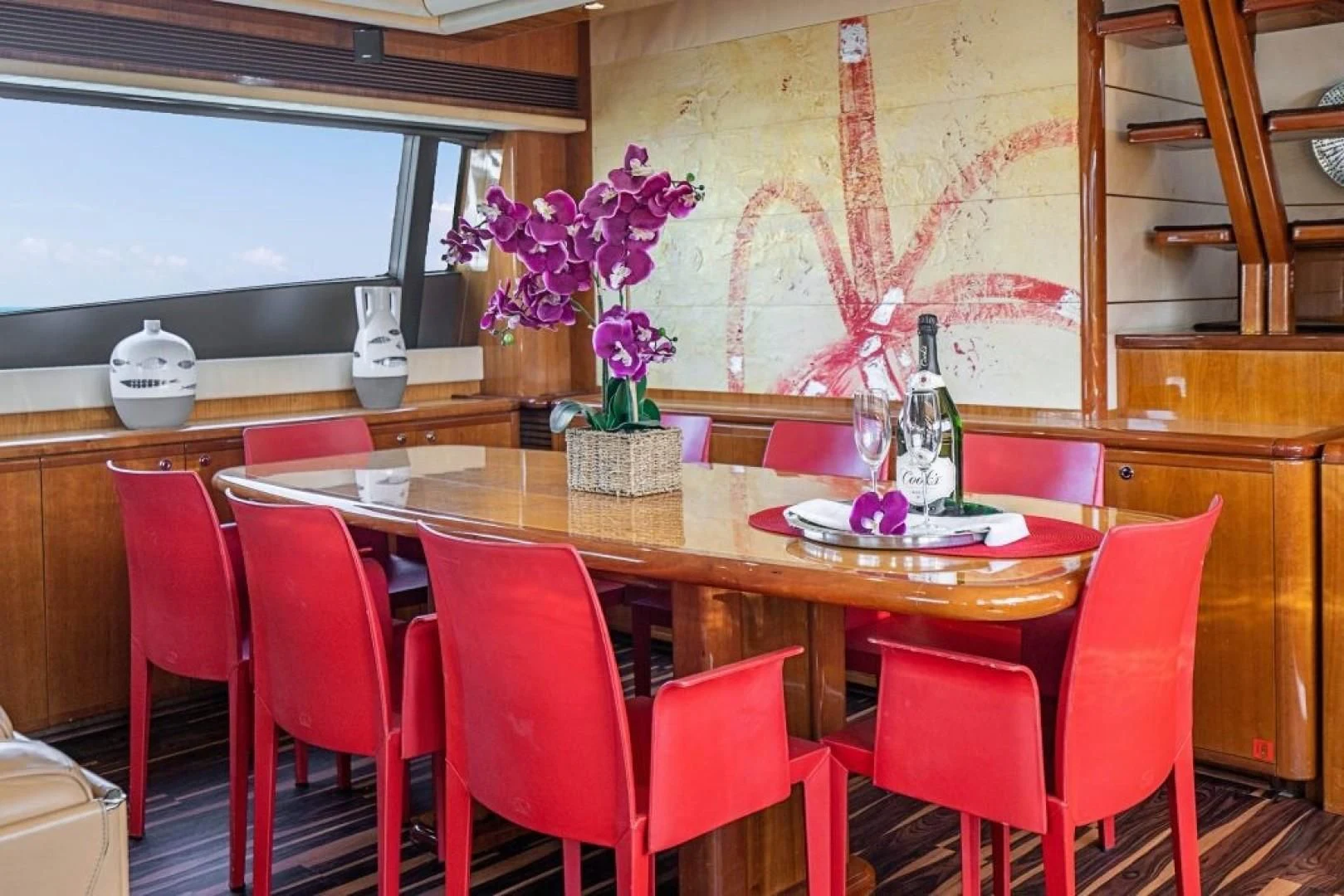 a dining table with red chairs aboard INDULGE II Yacht for Sale