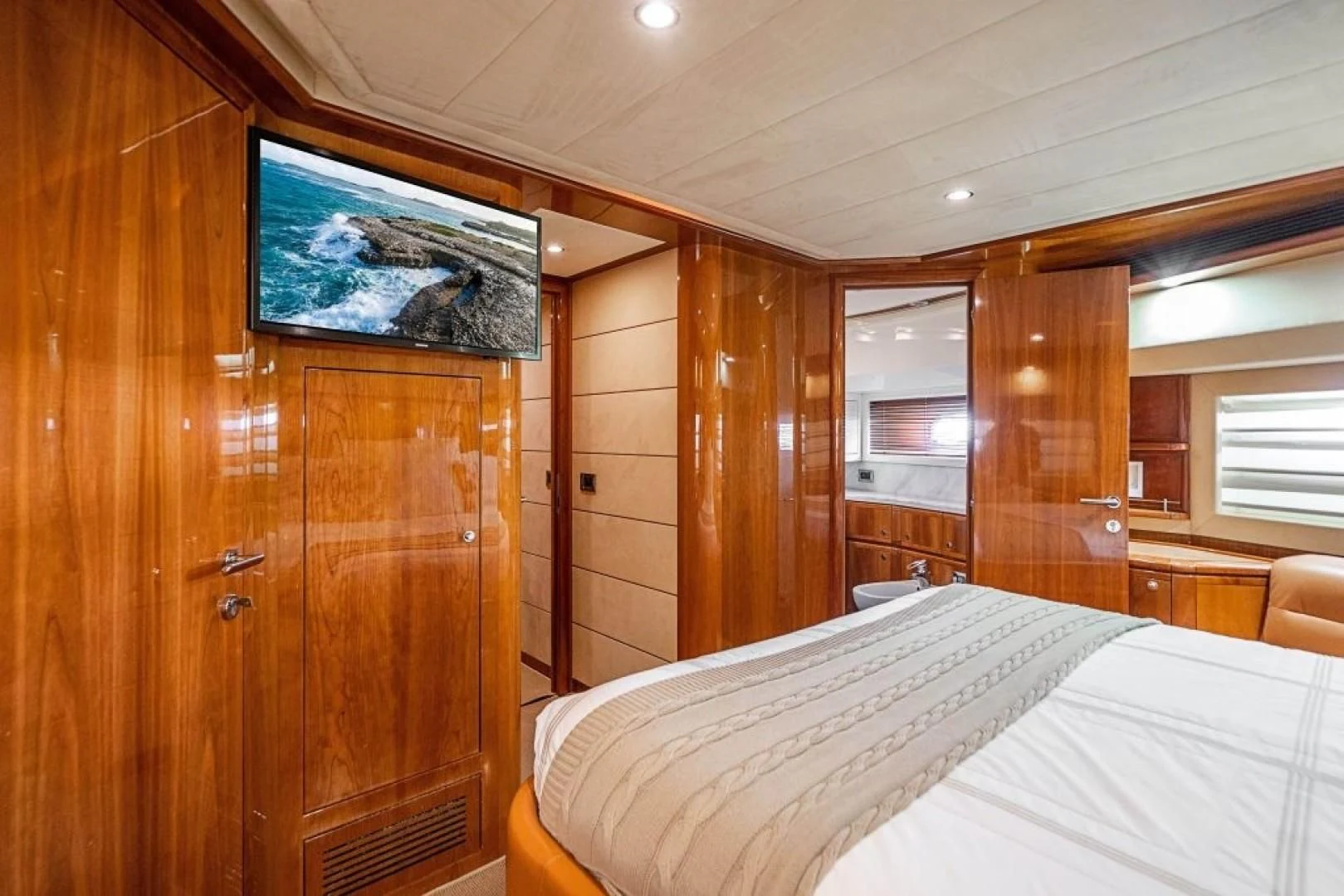 a room with a bed and a television aboard INDULGE II Yacht for Sale