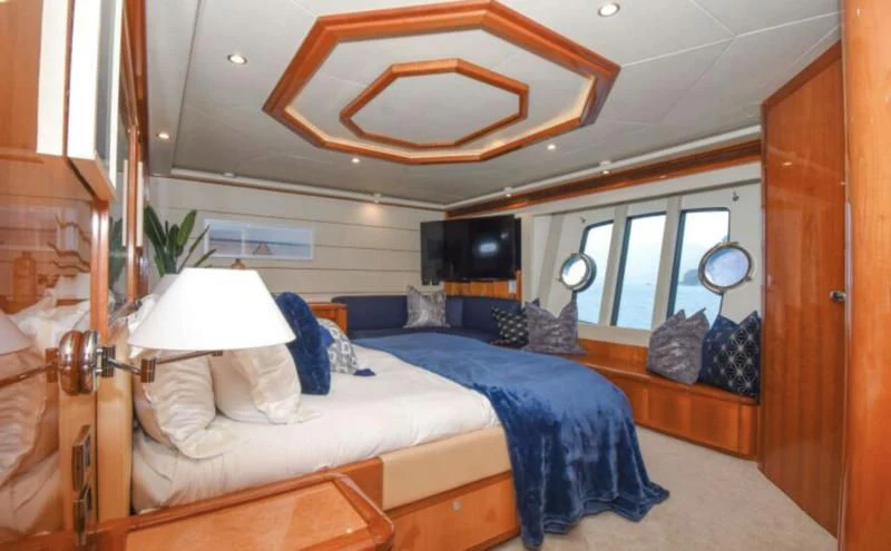 a room with a bed and a mirror aboard INDULGE II Yacht for Sale