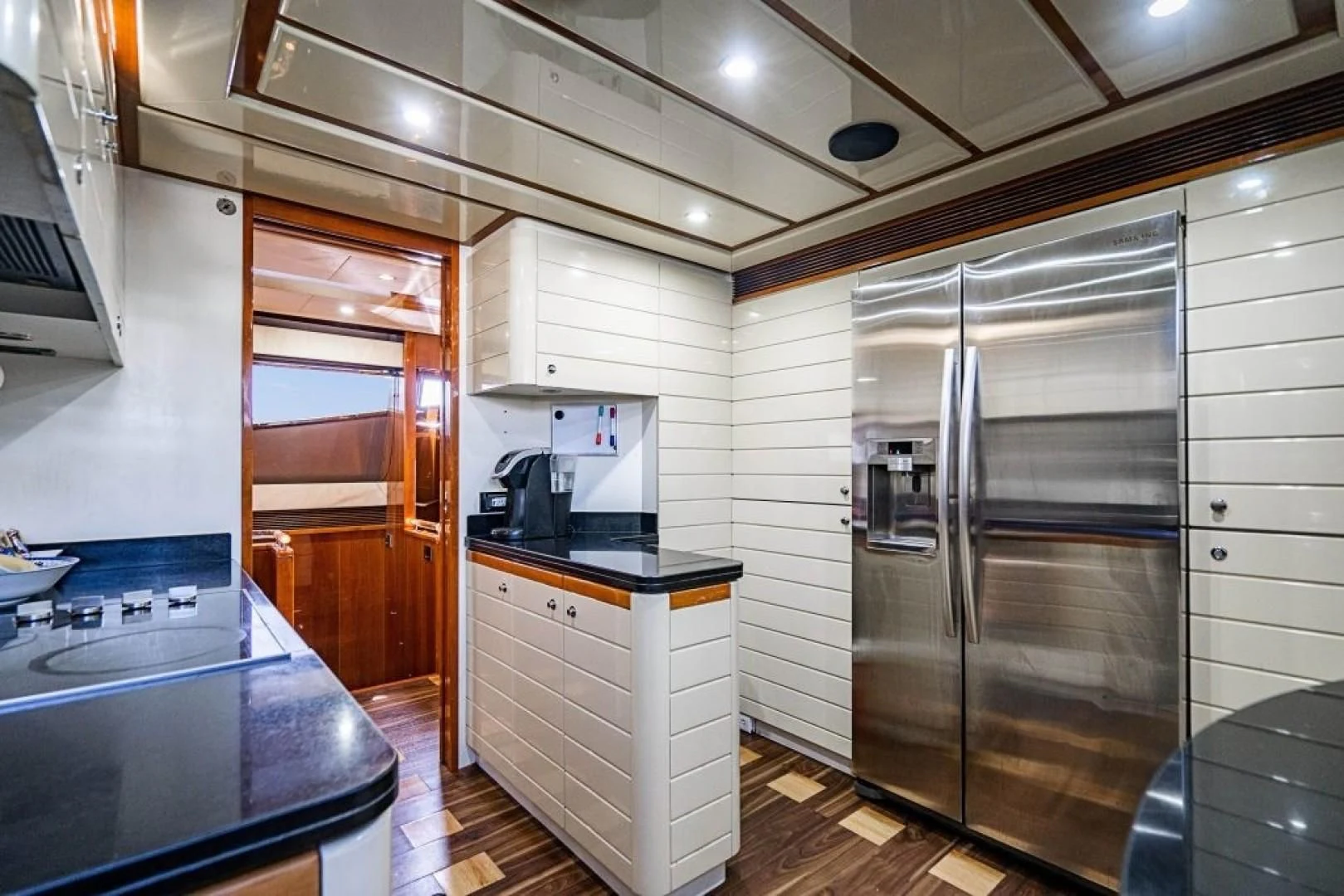 a kitchen with a refrigerator and microwave aboard INDULGE II Yacht for Sale