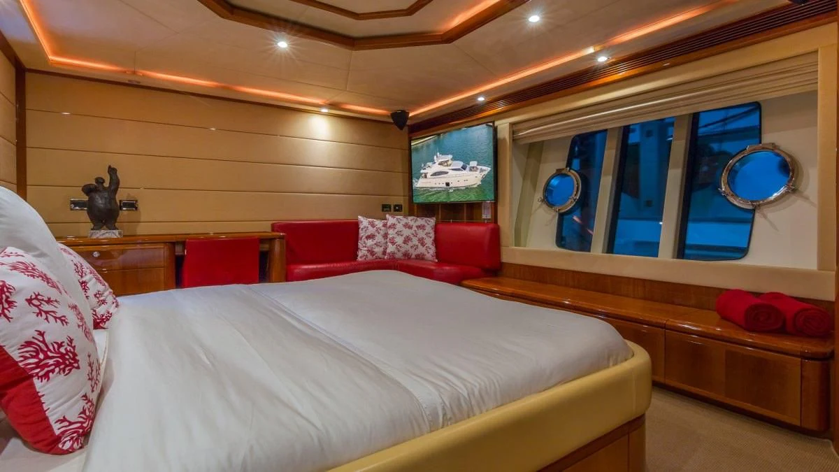 a room with a bed and a window aboard INDULGE II Yacht for Sale