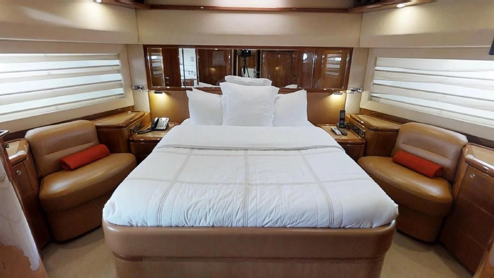 a bed with a white sheet and a couch in a room aboard INDULGE II Yacht for Sale