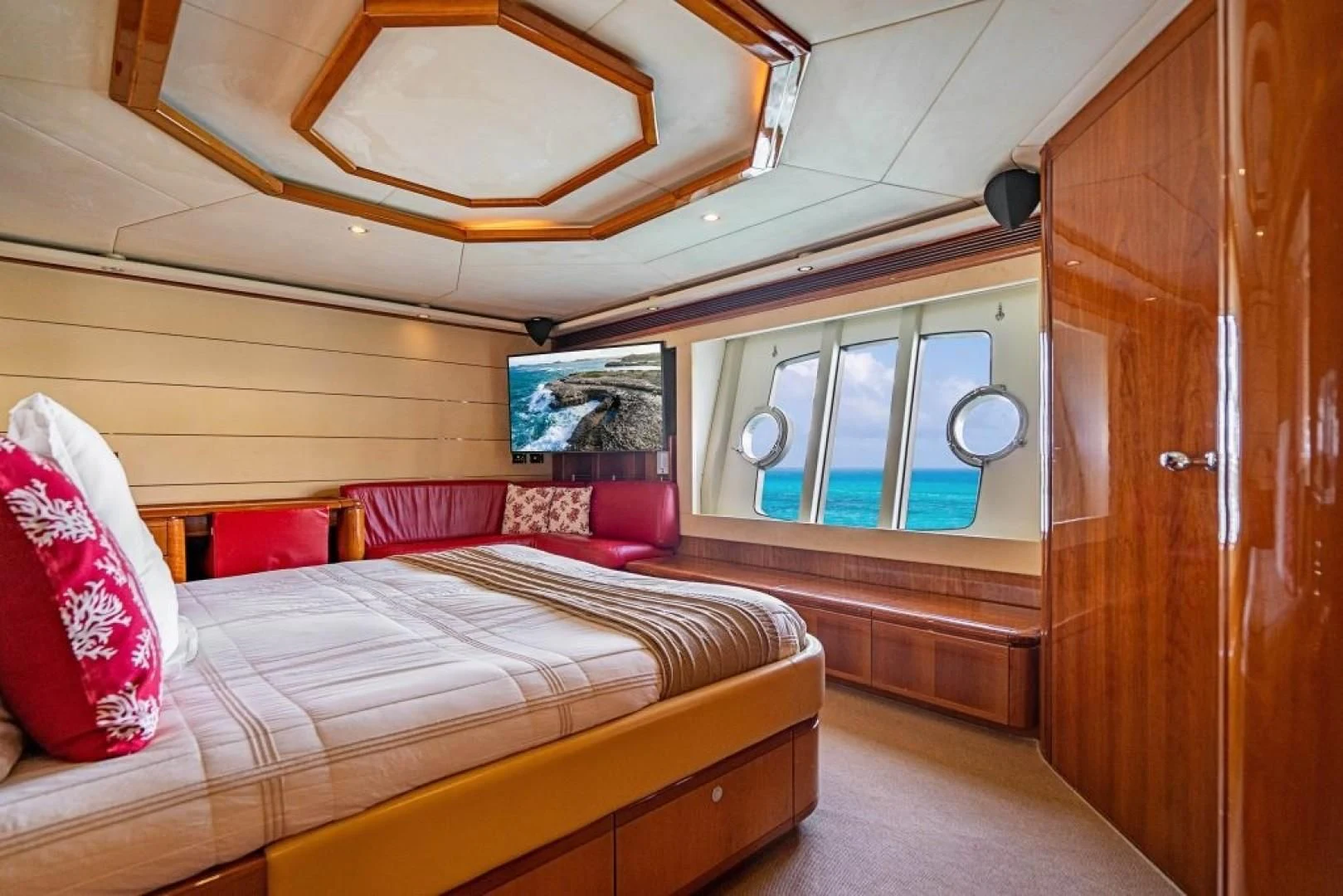 a room with a bed and a wood cabinet aboard INDULGE II Yacht for Sale