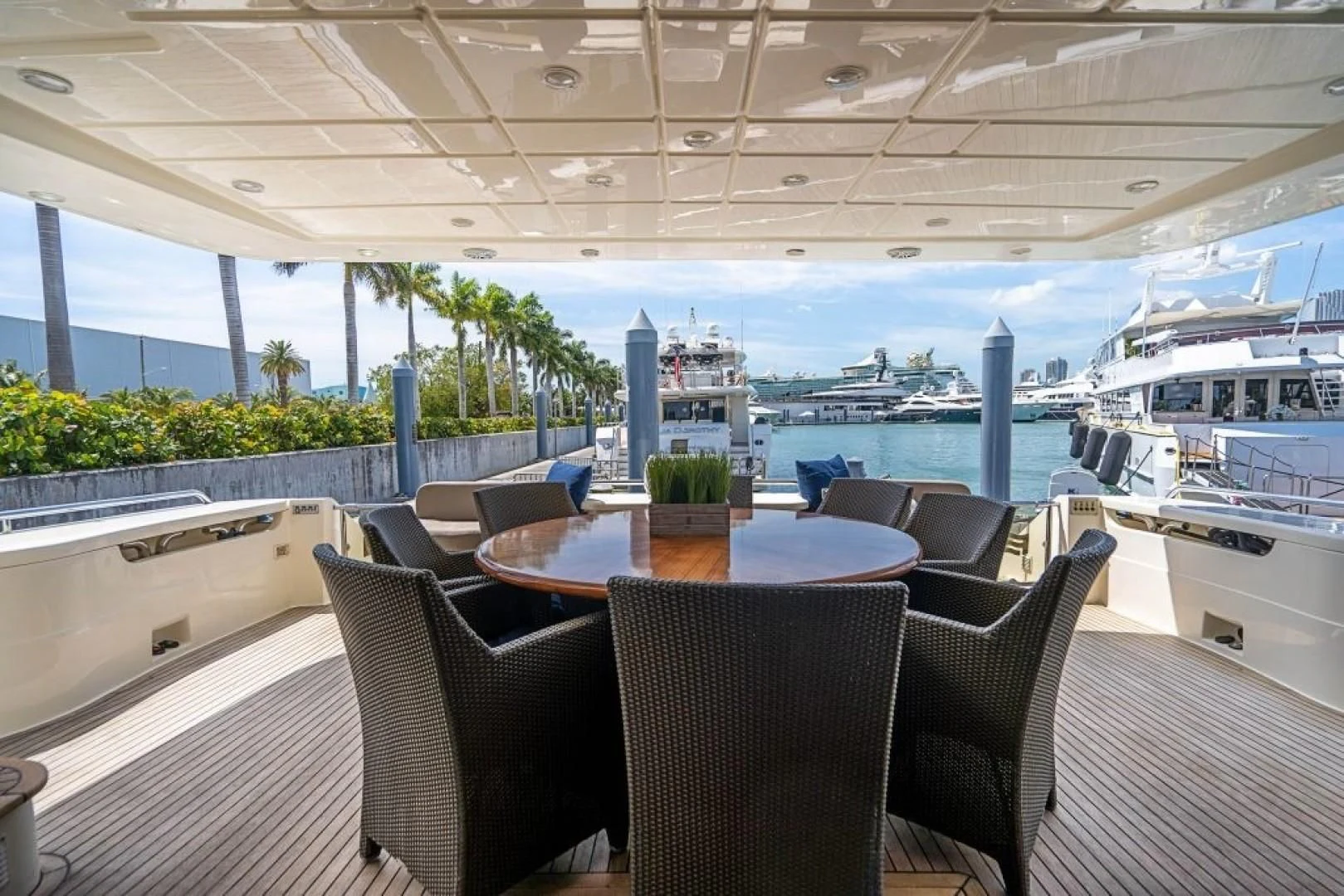 a table and chairs on a deck overlooking a large ship aboard INDULGE II Yacht for Sale