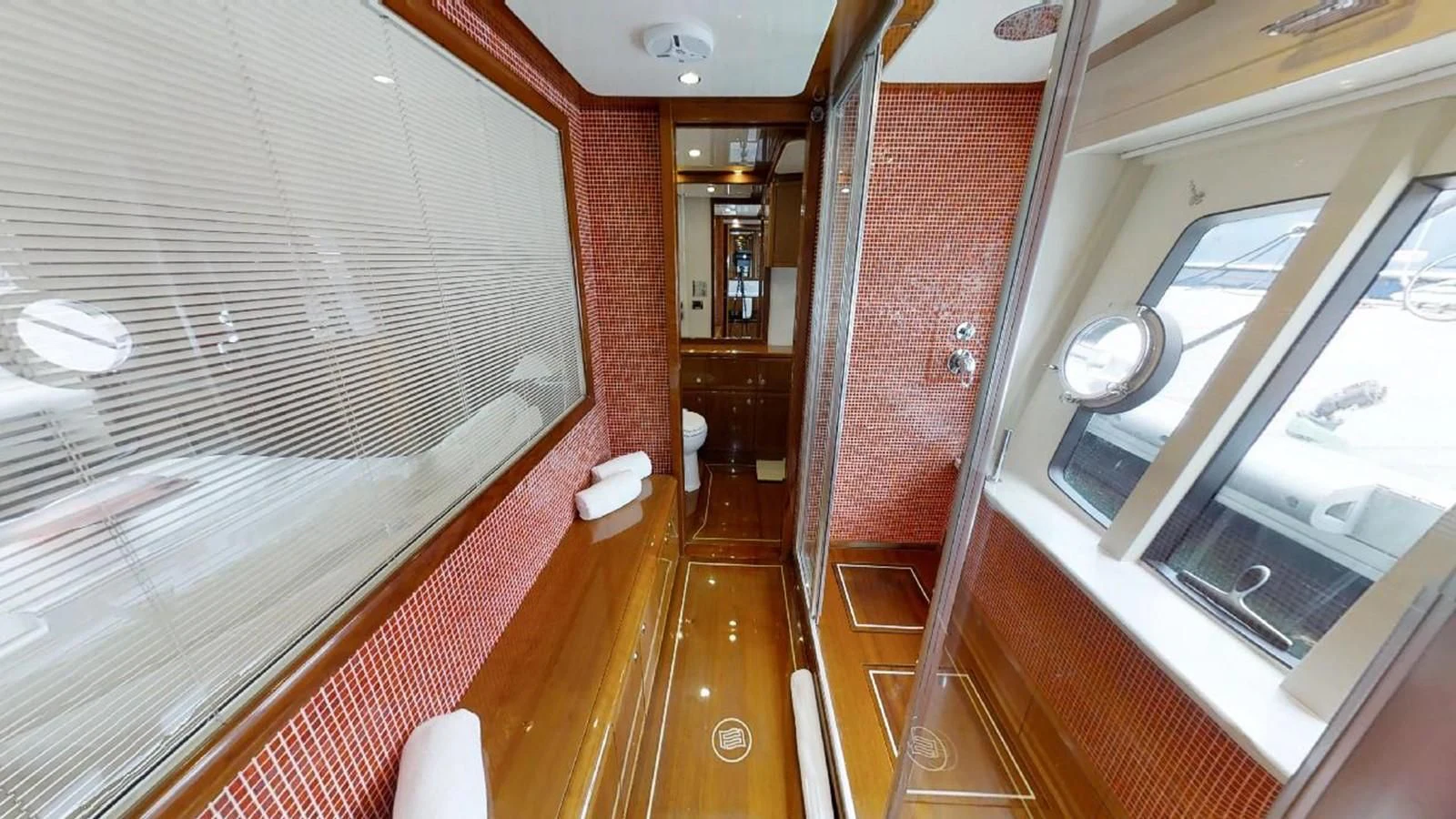 a hallway with a wood floor and a window aboard INDULGE II Yacht for Sale
