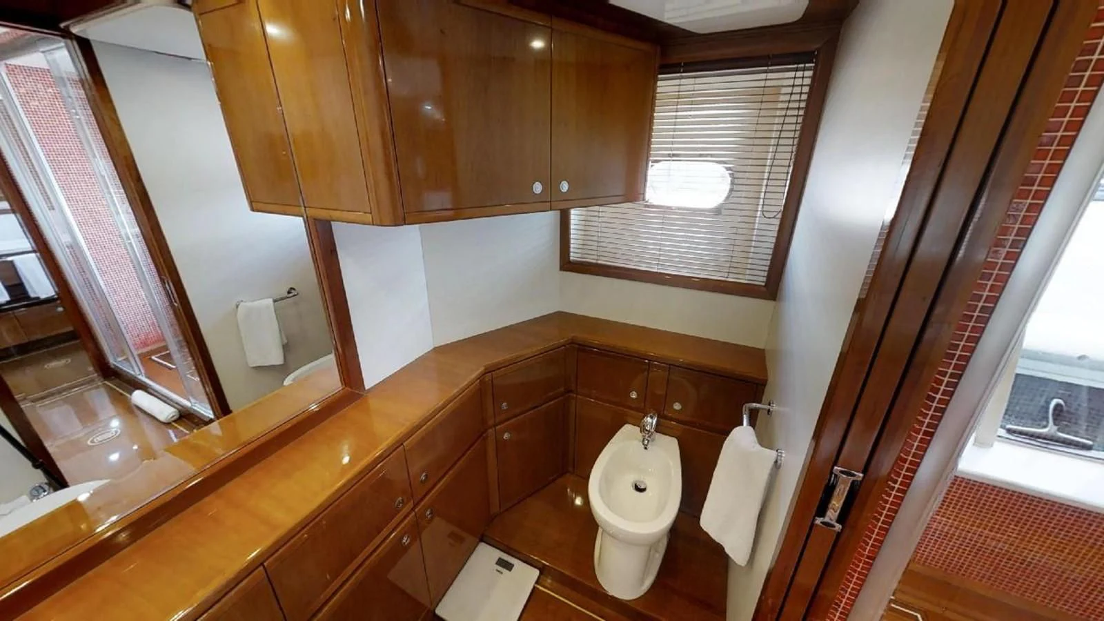 a bathroom with a toilet and a mirror aboard INDULGE II Yacht for Sale