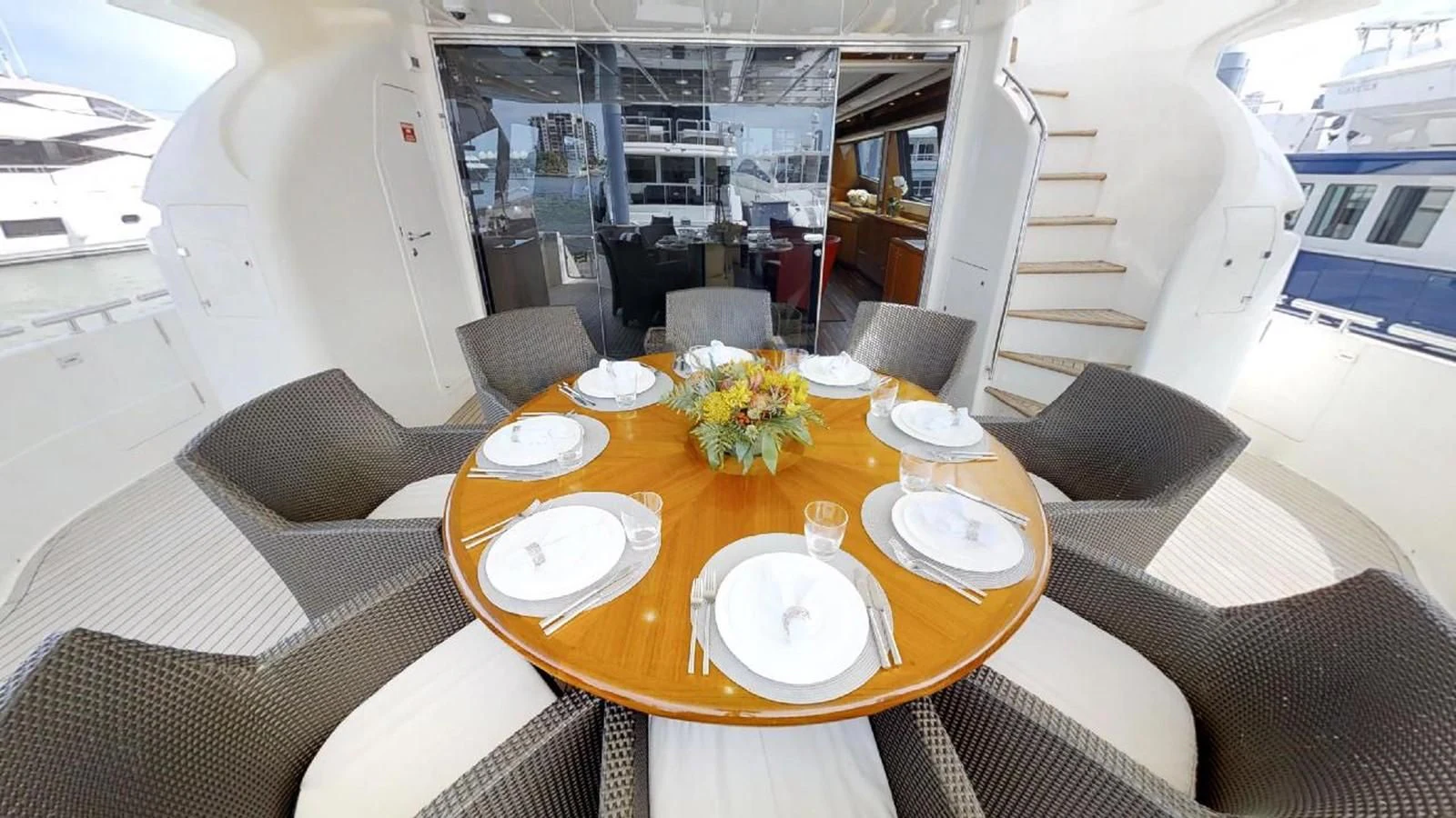 a dining table with plates and chairs aboard INDULGE II Yacht for Sale