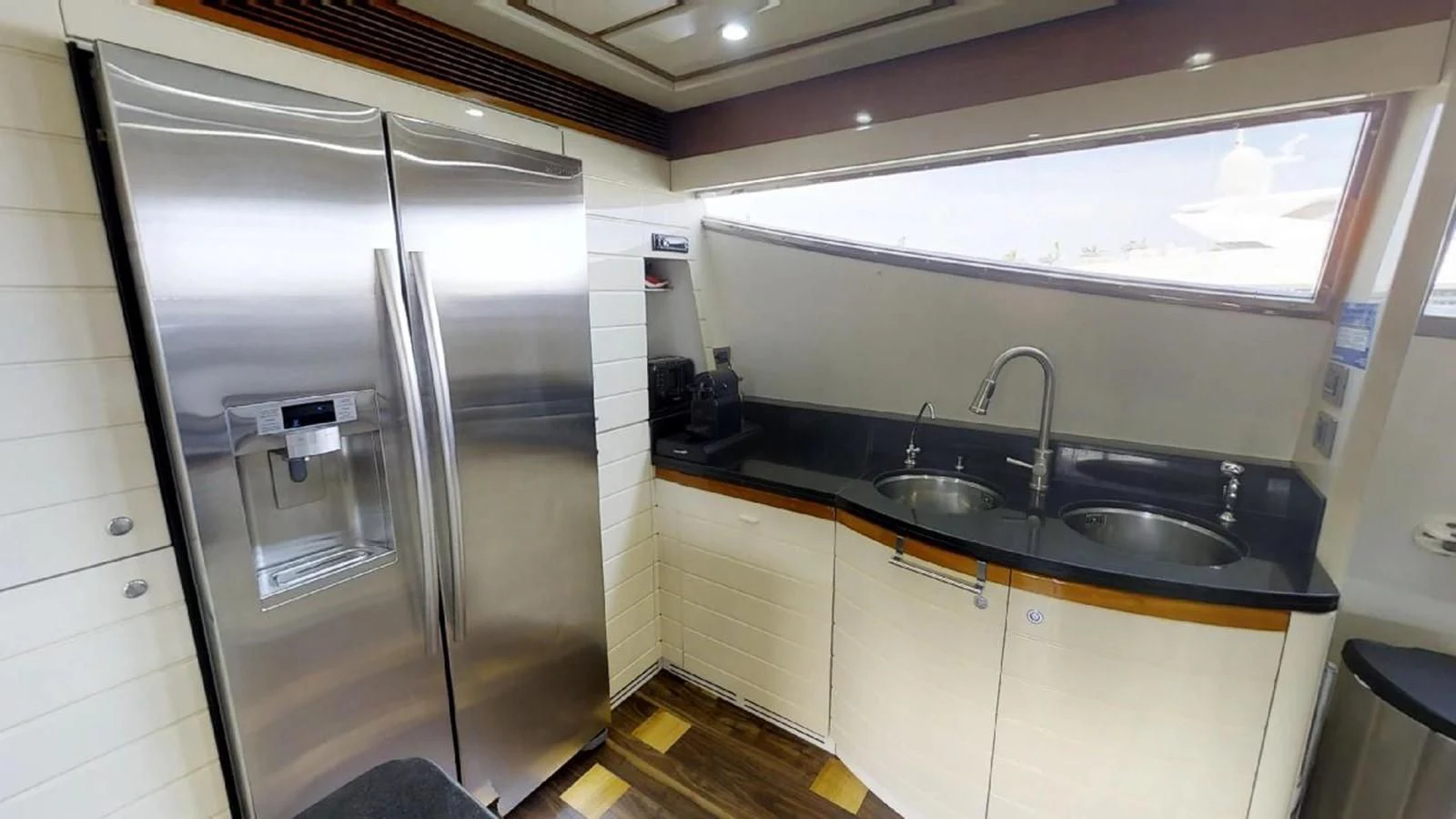 a kitchen with a stainless steel refrigerator aboard INDULGE II Yacht for Sale