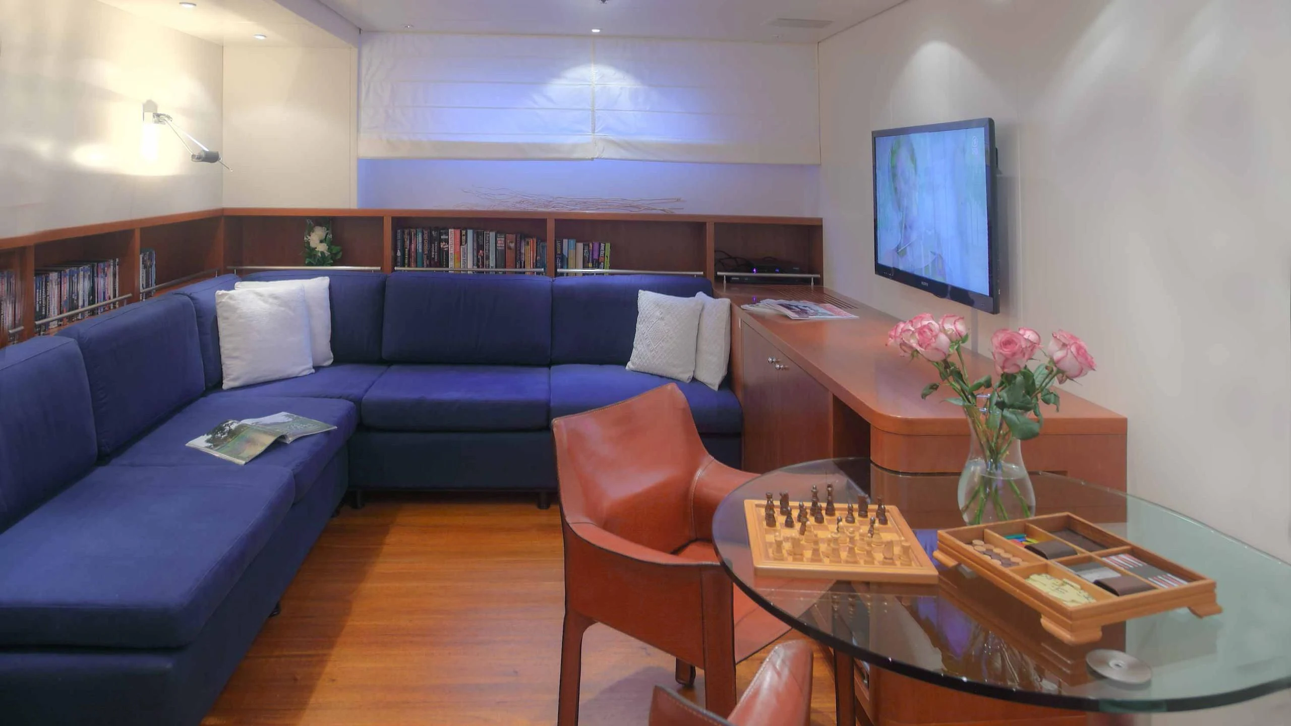 a living room with a blue couch and a coffee table aboard CAROM Yacht for Sale
