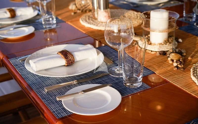 a table with plates and glasses aboard CAROM Yacht for Sale