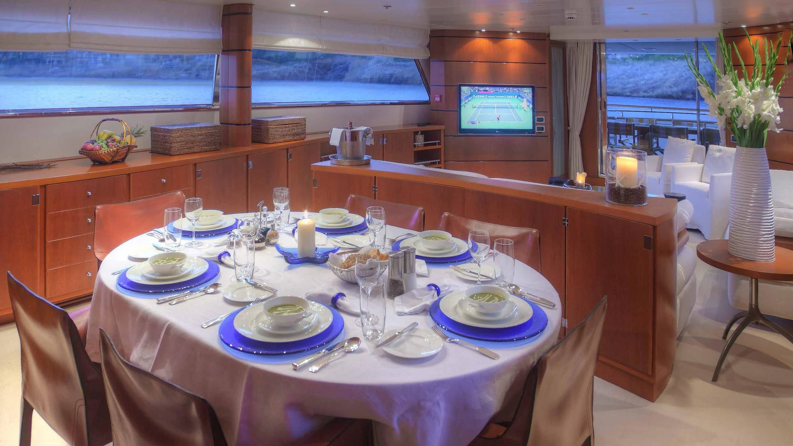 a table set with plates and glasses aboard CAROM Yacht for Sale