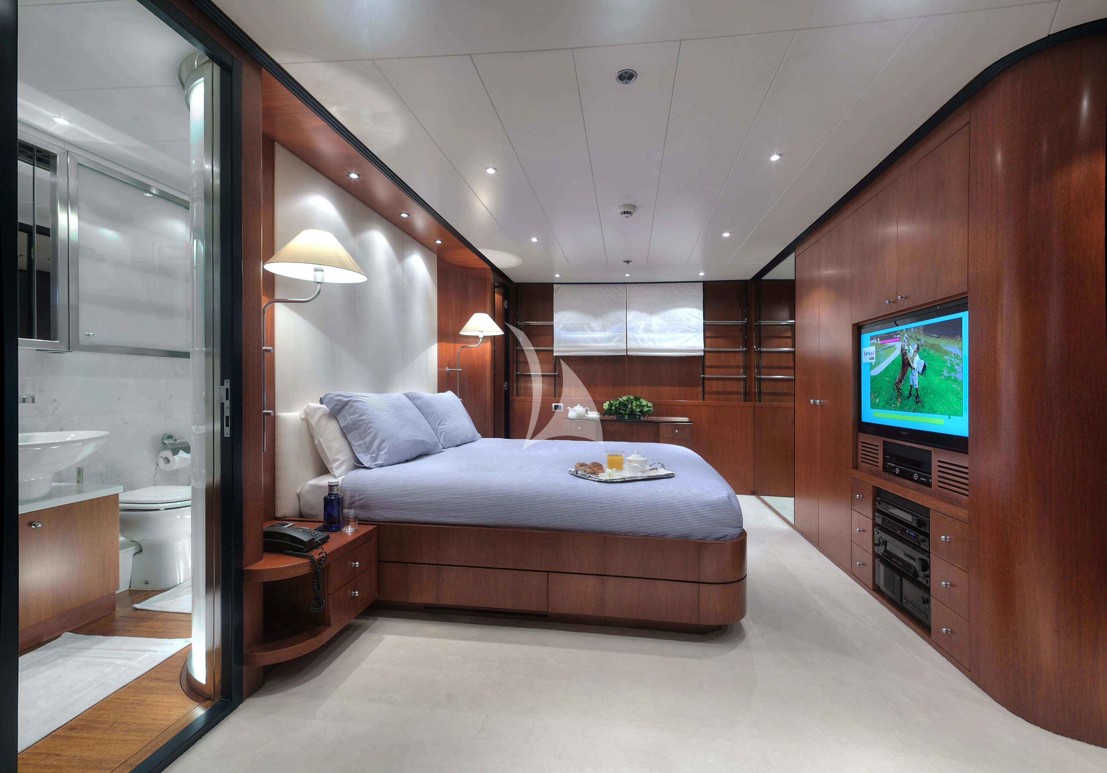 a bedroom with a bed and a tv aboard CAROM Yacht for Sale