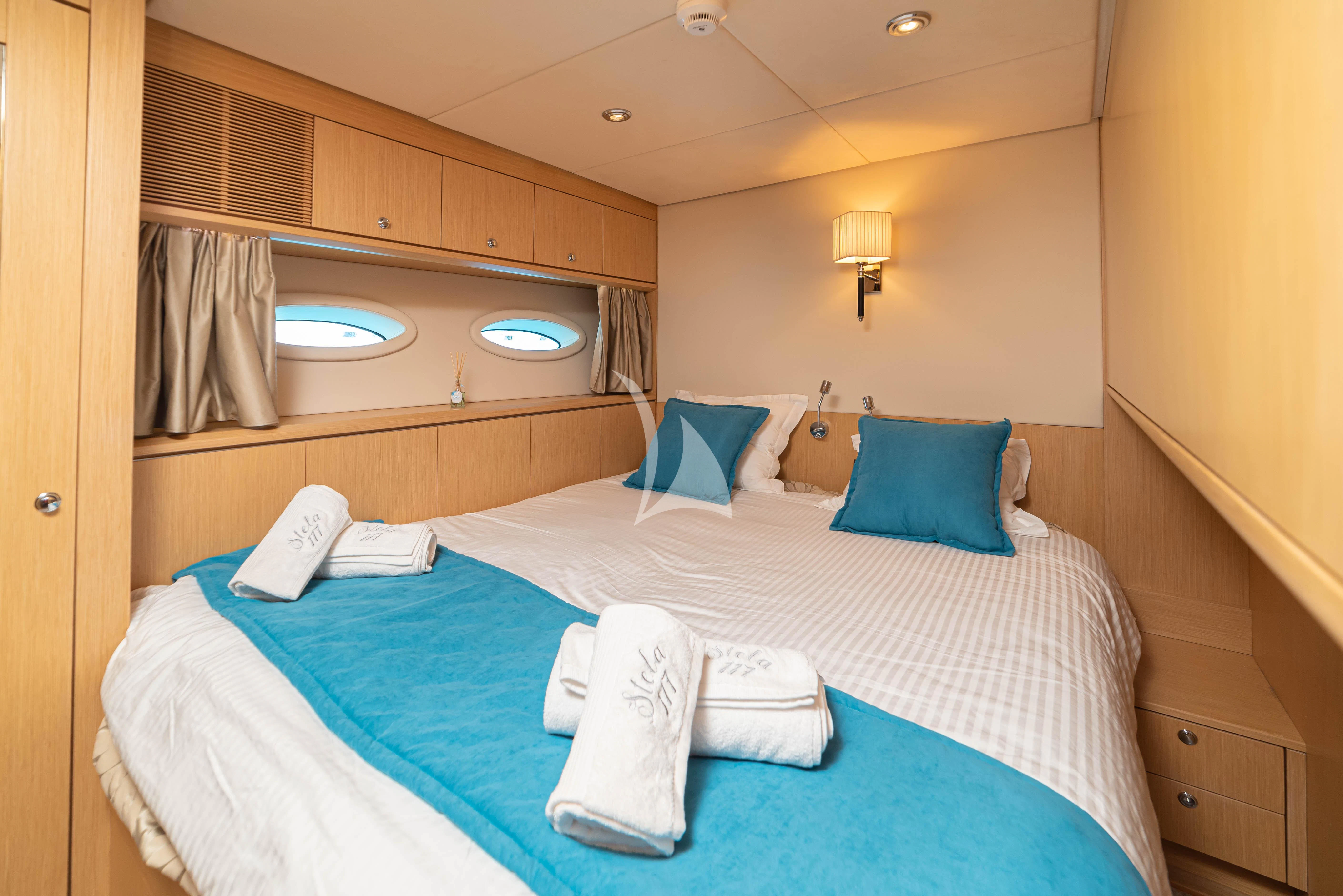 a bed with blue pillows aboard STELA 117 Yacht for Sale