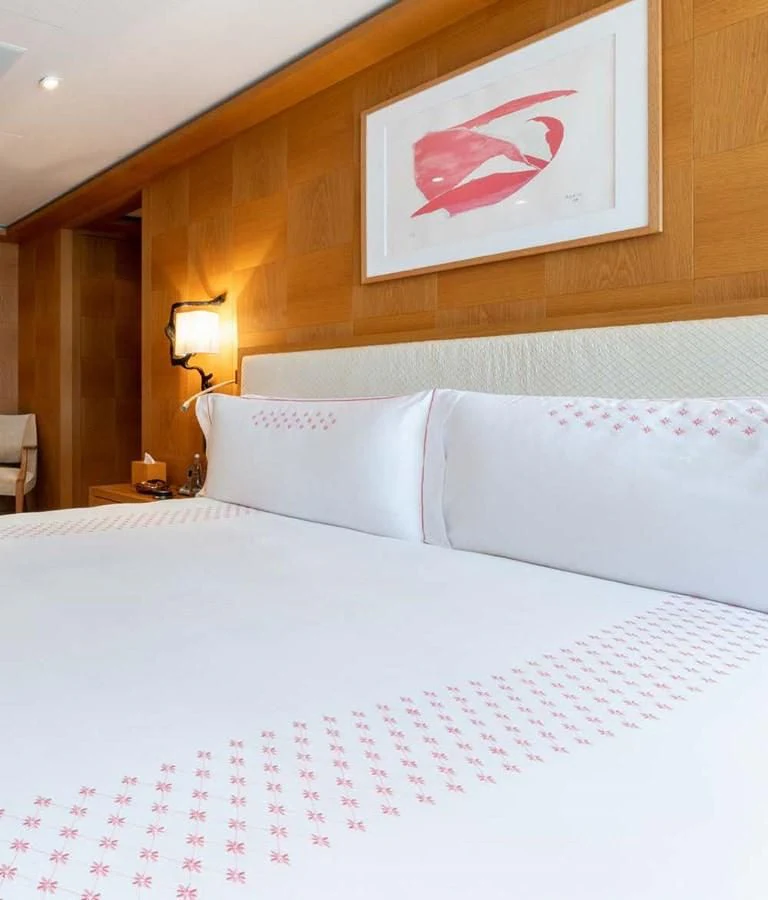 a bed with a white sheet and a picture on the wall aboard BATELLO Yacht for Sale