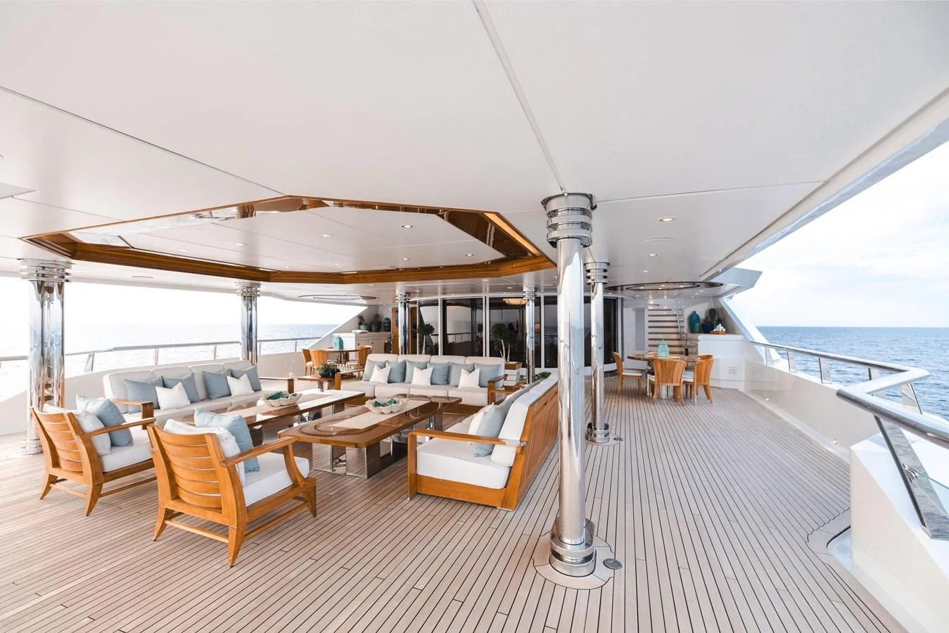 a room with a large deck and a large boat on the water aboard BATELLO Yacht for Sale