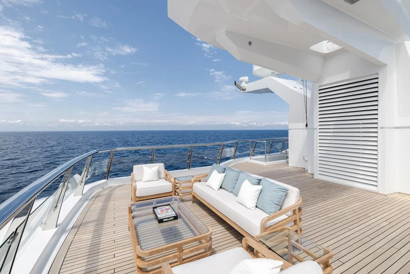 a balcony with a table and chairs on a deck overlooking the ocean aboard BATELLO Yacht for Sale