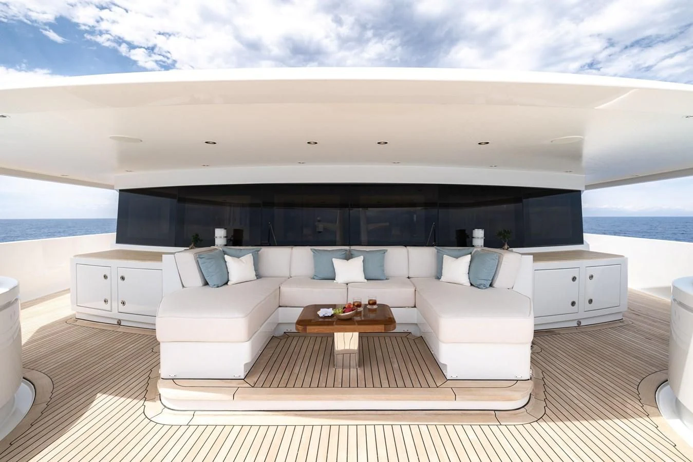a large white lounge chair next to a large black bed and white furniture aboard BATELLO Yacht for Sale