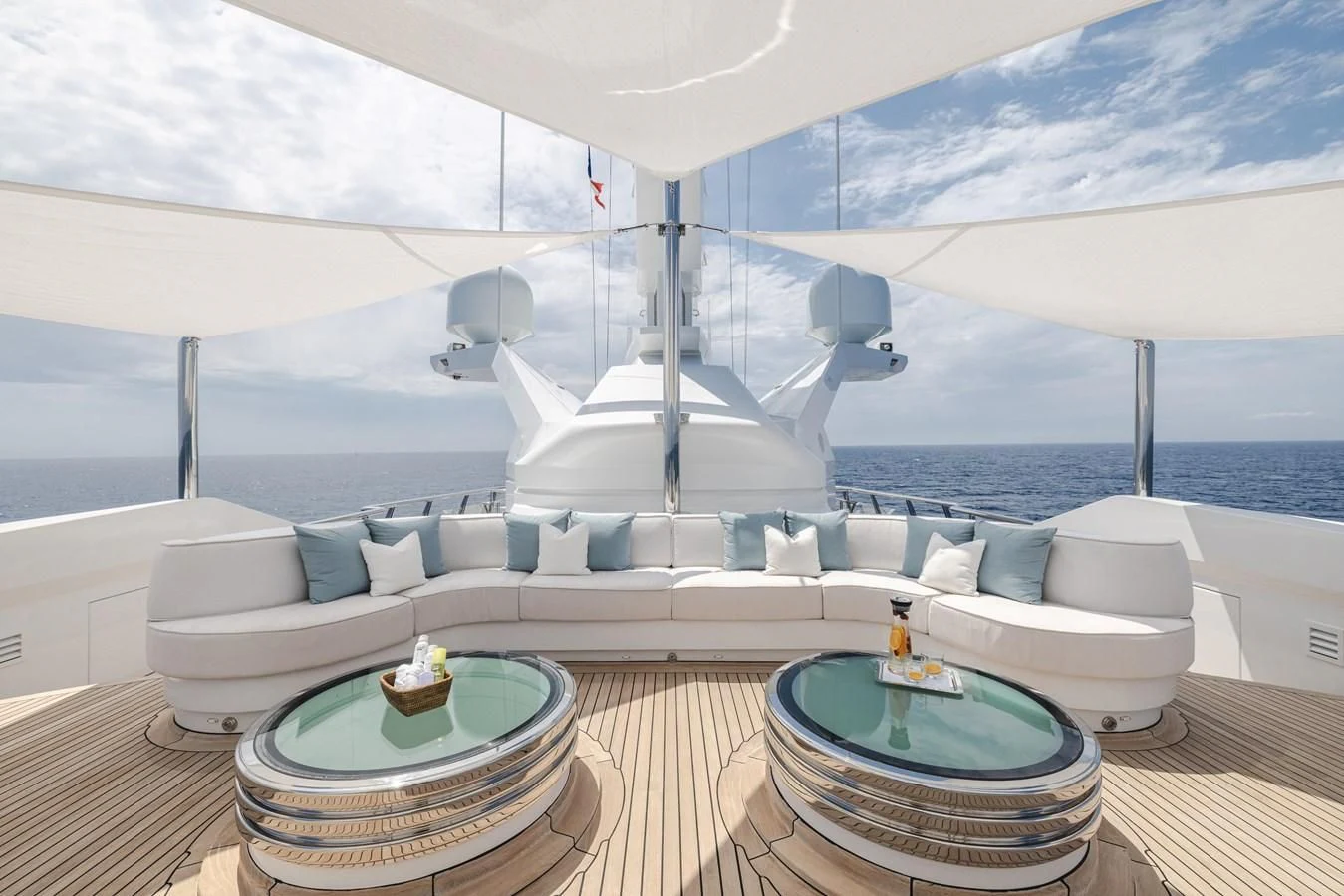 a modern white living room with a large white sofa and a table aboard BATELLO Yacht for Sale