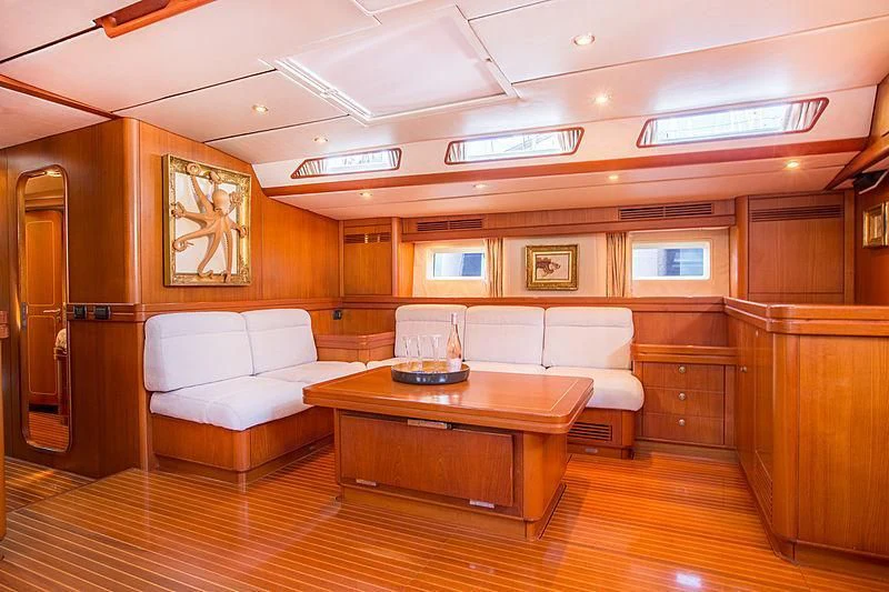 a room with a table and couch aboard PAN Yacht for Sale