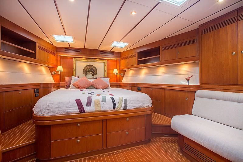 a bedroom with a bed and a couch aboard PAN Yacht for Sale