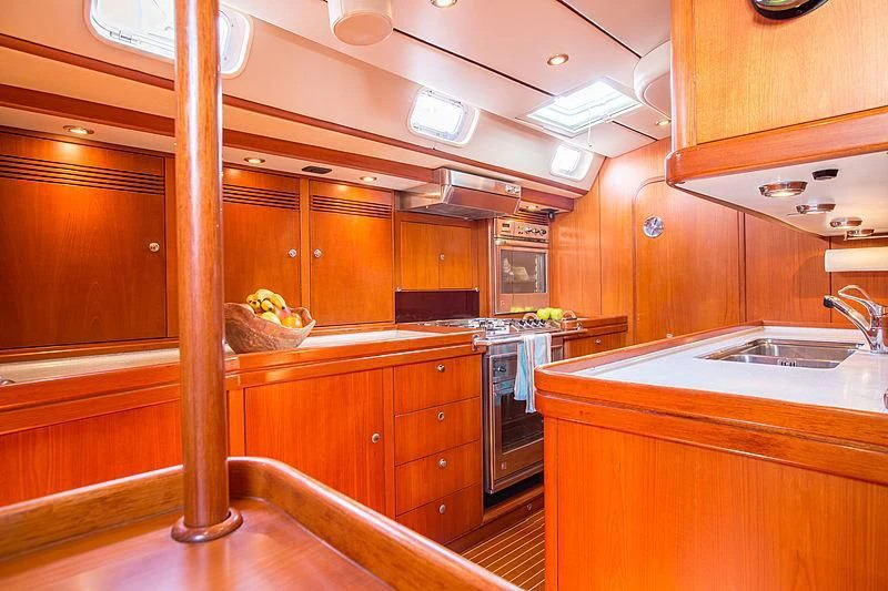 a kitchen with wooden cabinets aboard PAN Yacht for Sale